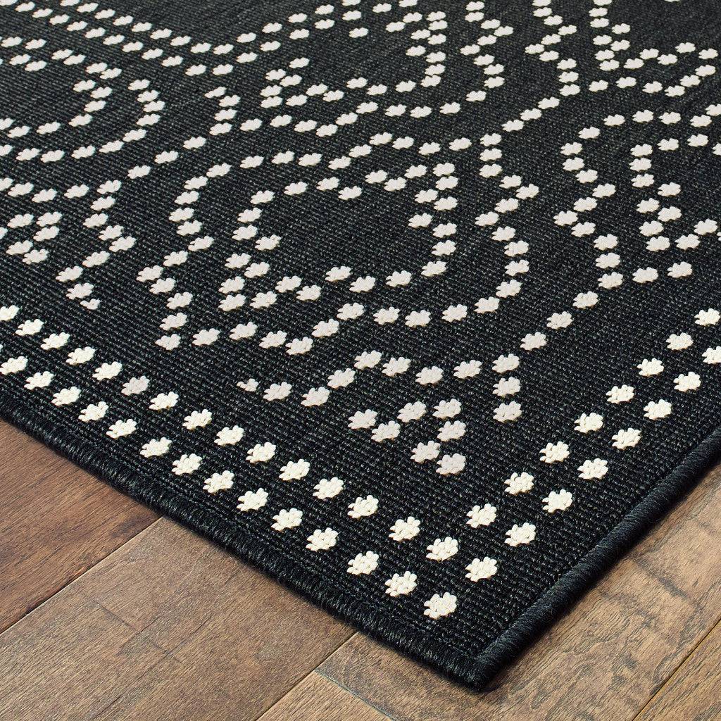 2' X 8' Black and Ivory Stain Resistant Indoor Outdoor Area Rug